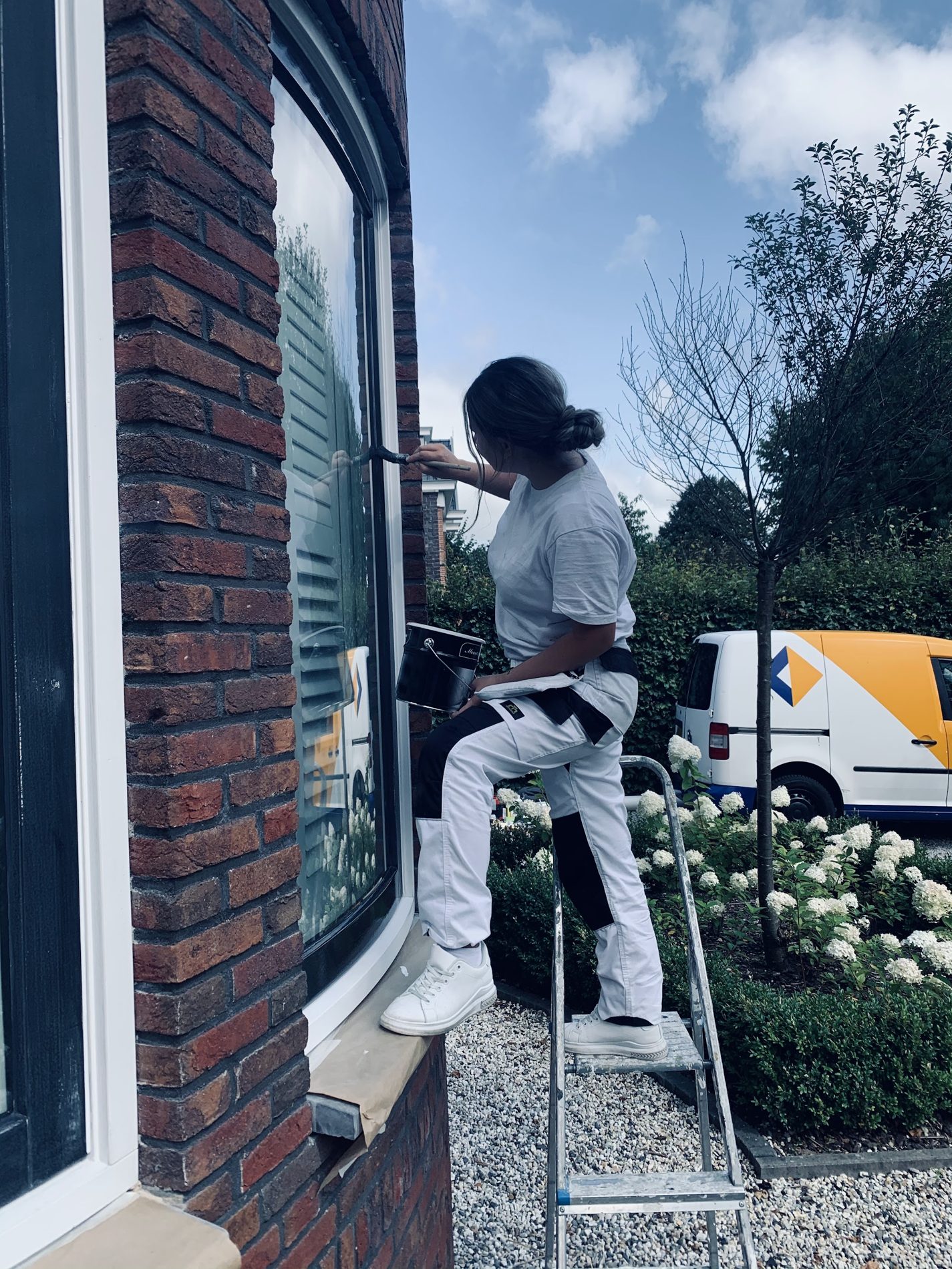 Schilder op een trapje aan een erkerraam